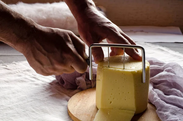 El hombre corta el queso en un primer plano de madera —  Fotos de Stock