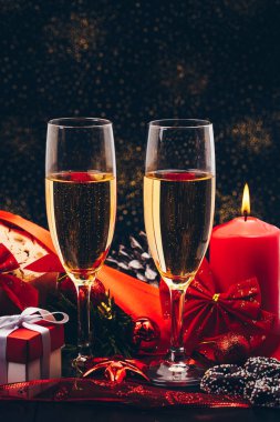 Noel ve yeni yıl. Şampanya gözlük mumlar, panettone ve kırmızı saten fiyonklu hediye paketi. Boşluk. Festival kavramı