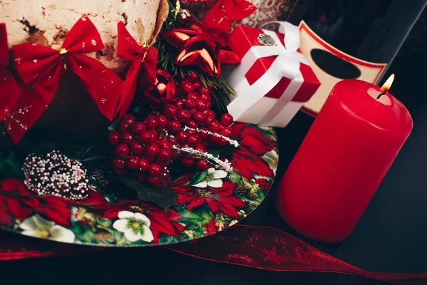 圣诞节或新的一年。在用蜡烛、 潘妮托妮和礼品红缎蝴蝶结眼镜香槟. — 图库照片