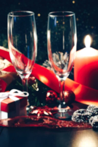 抽象模糊的背景︰ 圣诞节或新的一年。在用蜡烛、 潘妮托妮和礼品红缎蝴蝶结眼镜的香槟。副本-空间。节日的概念 — 图库照片