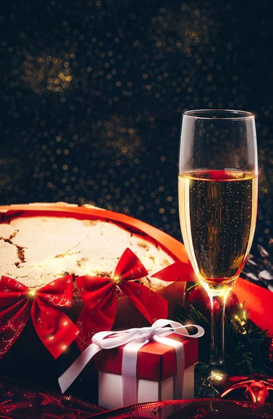 圣诞节或新的一年。在用蜡烛、 潘妮托妮和礼品红缎蝴蝶结眼镜的香槟。副本-空间。节日的概念 — 图库照片