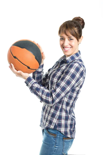 Feliz joven atractiva sosteniendo una pelota de baloncesto aislada en blanco Imagen de archivo