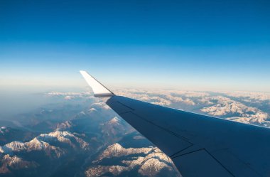 Pencere uçak uçuş sırasında bir kar seyir İtalyanca ve Osterreich Alps bulutlar olmadan mavi gökyüzü ile kaplı.