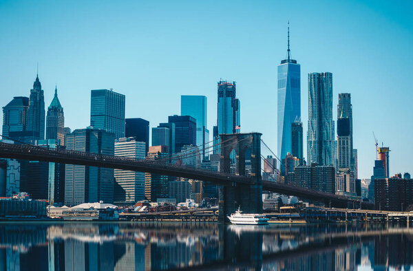 View of Brooklyn Bridge and Manhattan skyline WTC Freedom Tower from Dumbo, Brooklyn. Brooklyn Bridge is one of the oldest suspension bridges.