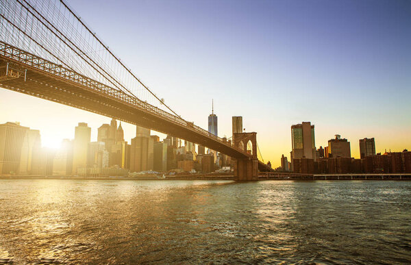 View of Brooklyn Bridge and Manhattan skyline WTC Freedom Tower from Dumbo at sunset, Brooklyn. Brooklyn Bridge is one of the oldest suspension bridges in the USA