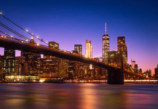 Utsikt över Brooklyn Bridge och Manhattan skyline Wtc Freedom Tower från Dumbo på natten, Brooklyn. Brooklyn Bridge är en av de äldsta hängbroar i Usa — Stockfoto