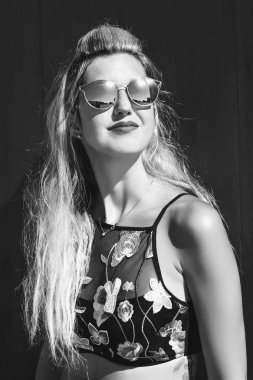 Uzak bir tarafına bakarak ahşap bankta oturan gözlüklü casual giyim yakışıklı genç kadın portresi. Tonlu görüntü renk. Kavramı kentsel yaşam.