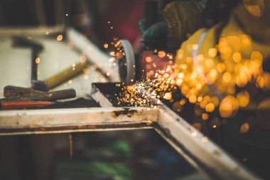 Usta disk açı değirmeni bir depo ile metal testere ile kesme.