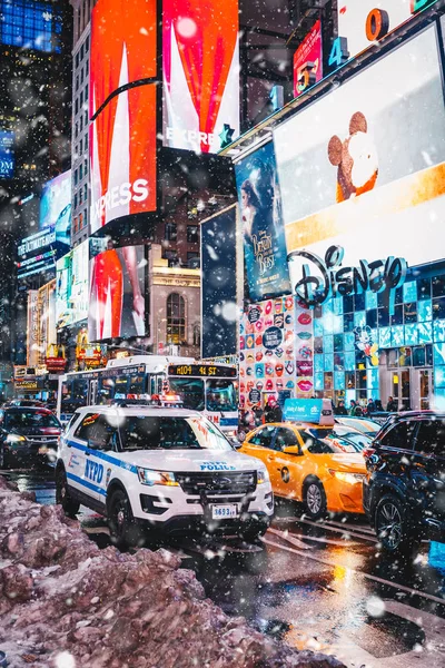 New York City, Amerika Birleşik Devletleri - 18 Mart 2017: İnsanlar ve Times Meydanı'nda ünlü led reklam paneller sırasında kar, New York şehrinin sembolü. 