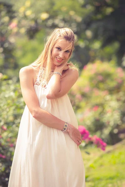Uśmiechnięta Blondynka Sukience Spacerująca Kwitnącym Ogrodzie Niewyraźne Tło — Zdjęcie stockowe
