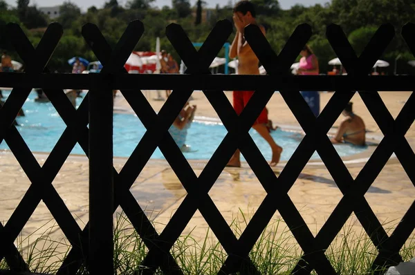 Pool fence and a young man walking