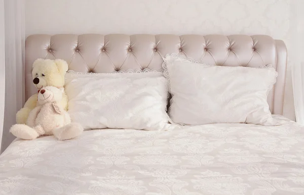 Gran cama blanca con dos almohadas y osos de peluche —  Fotos de Stock