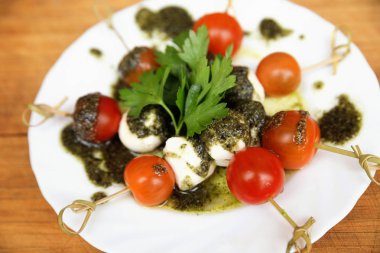 Caprese salatası domates ve mozzarella ile maydanoz ve otlar üzerinde bir 