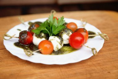 Caprese salatası domates ve mozzarella ile maydanoz ve otlar üzerinde bir 