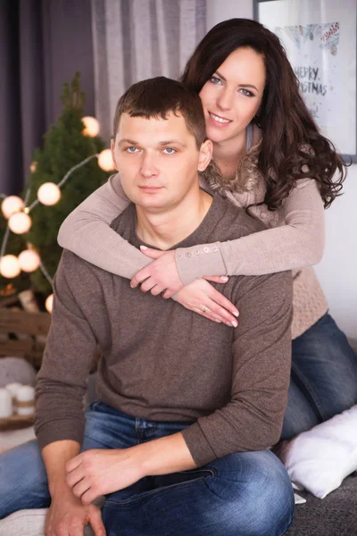 Hermosa pareja joven que se relaja en una sala de estar con año nuevo t — Foto de Stock