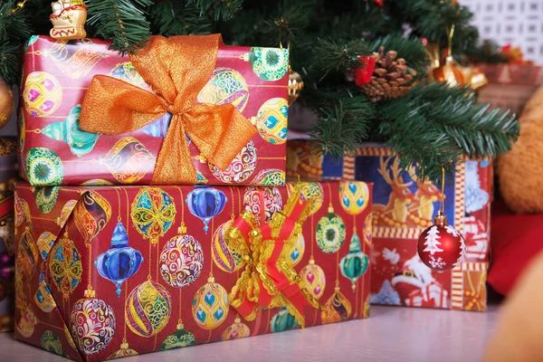 Huidige dozen op de vloer met een kerstboom op achtergrond — Stockfoto