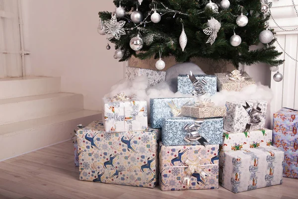 Huidige dozen op de vloer met een kerstboom op achtergrond — Stockfoto
