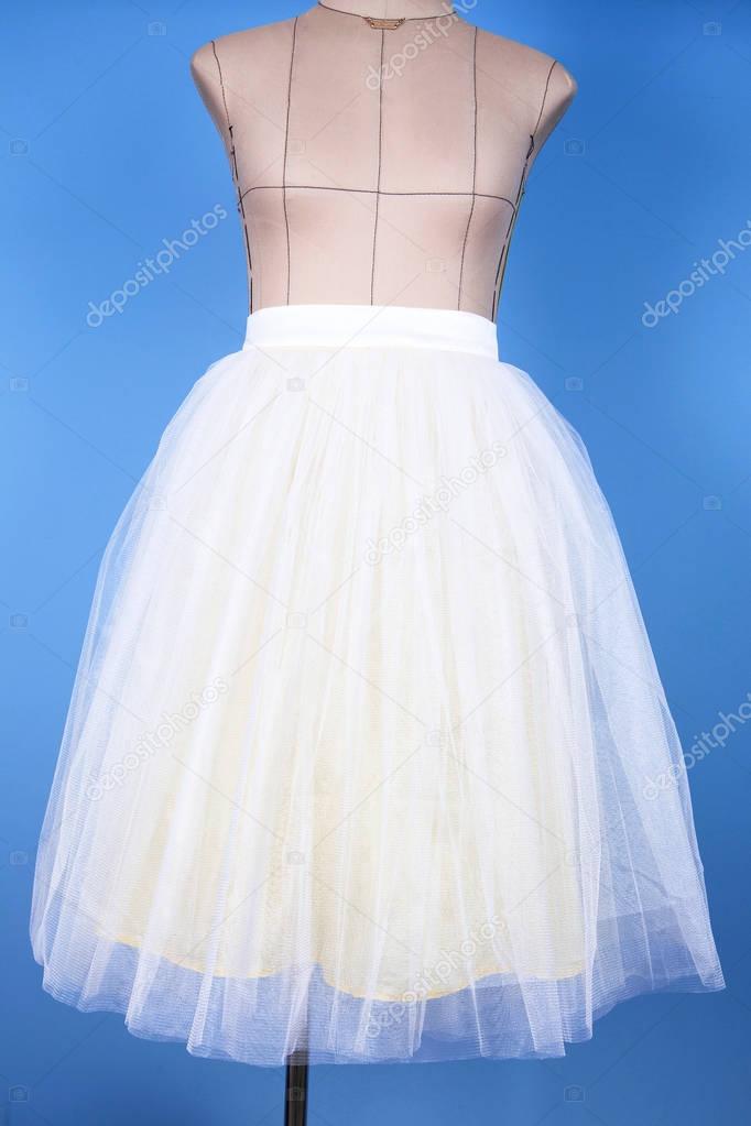 Mannequin in white princess skirt on blue background
