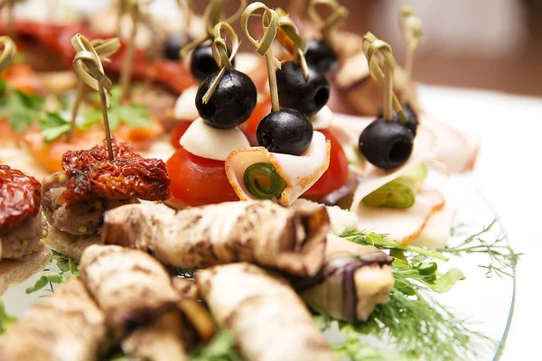 Primo piano di rotoli di prosciutto decorato con olive nere — Foto Stock