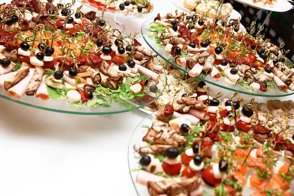 A lot of snacks with skewers and sandwiches on buffet table — Stock Photo, Image