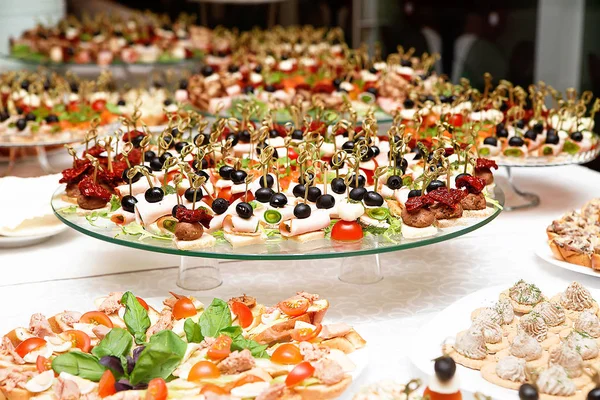 Um monte de lanches com espetos e sanduíches na mesa buffet — Fotografia de Stock