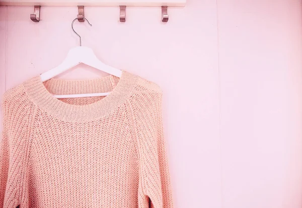 Smart inverno indossare maglione su un appendiabiti su sfondo bianco parete — Foto Stock