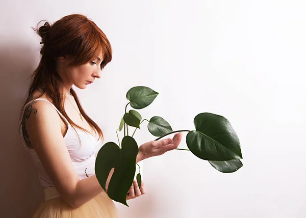 흰색 바탕에 녹색 식물을 가진 소녀 — 스톡 사진