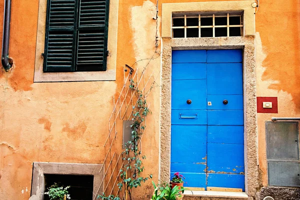 Klassisches italienisches Haus mit blauer Tür und orangefarbenen Wänden — Stockfoto