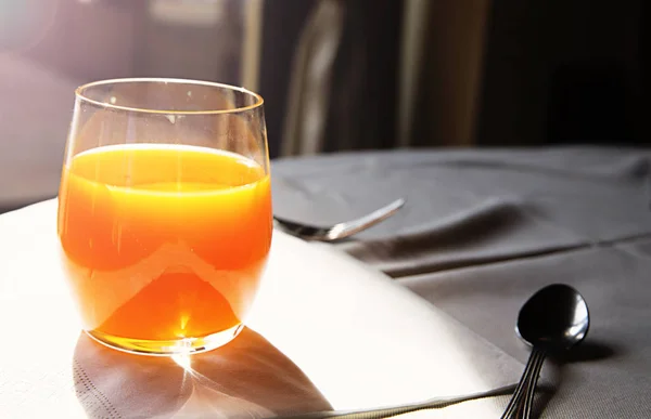 Sklenice čerstvého pomerančového džusu a slunečné ráno — Stock fotografie