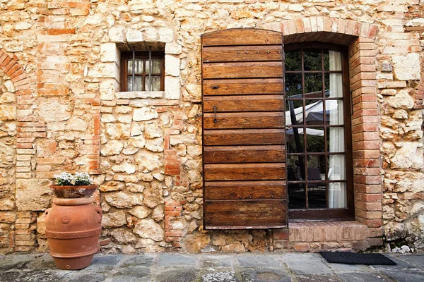 Alte toskanische Mauer - braune Tür in einer mittelalterlichen Stein- und Ziegelmauer — Stockfoto