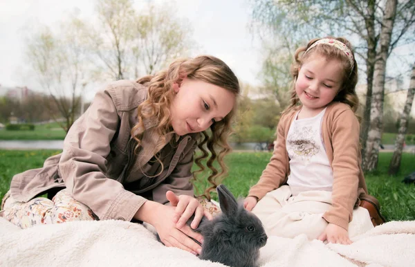 Deux filles jouant avec le lapin dans le parc — Photo