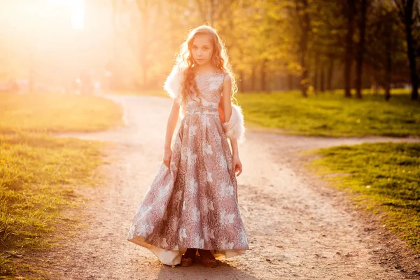 Menina de vestido e casaco de pele nos raios de sol — Fotografia de Stock