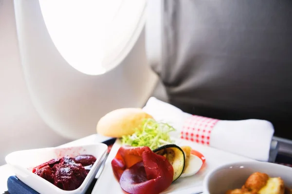 Comida servida a bordo de un avión de clase ejecutiva sobre la mesa — Foto de Stock