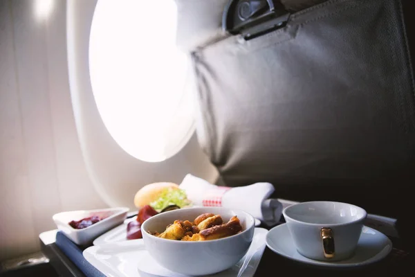 Comida servida a bordo de un avión de clase ejecutiva sobre la mesa — Foto de Stock