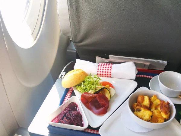 Comida servida a bordo de un avión de clase ejecutiva sobre la mesa — Foto de Stock