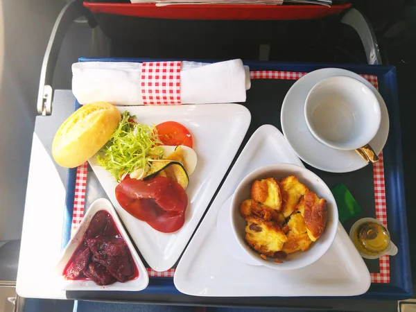 Comida servida a bordo de un avión de clase ejecutiva sobre la mesa — Foto de Stock