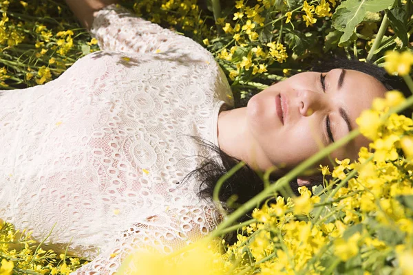 Beautiful young girl in a field of flowers — Stock Photo, Image