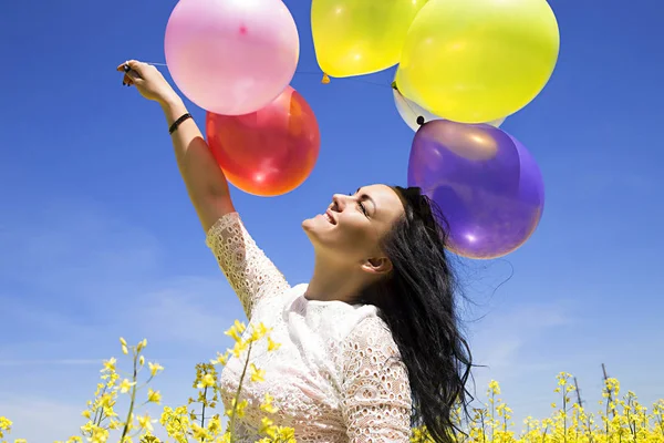 Молода красива жінка тримає кольорову кульку насолоджуватися зі свіжим — стокове фото
