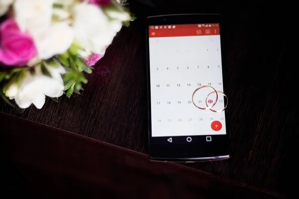 Snubní prsteny na mobilním telefonu — Stock fotografie
