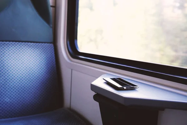 Telefone celular no assento da janela em um trem confortável moderno — Fotografia de Stock