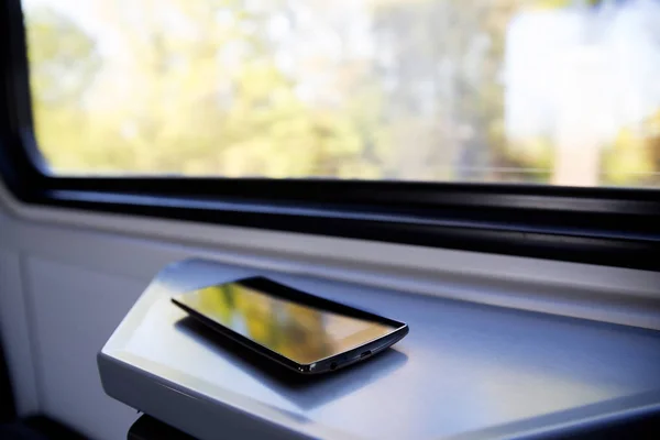 Mobile phone on window seat in a modern comfortable train