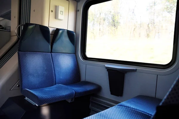 Cuatro asientos azules uno frente al otro en el moderno tren europeo — Foto de Stock