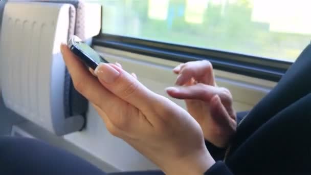 Kvinna sitter på ett tåg som med sin telefon — Stockvideo