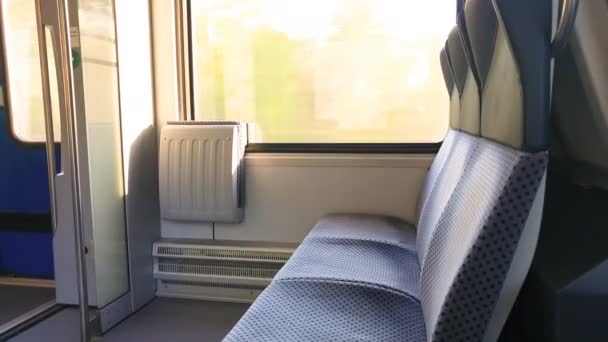 Ve vlaku vedle okna jsou dvě židle a dveře — Stock video