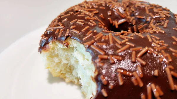 Bitten delicious donut on plate close-up — Stock Photo, Image