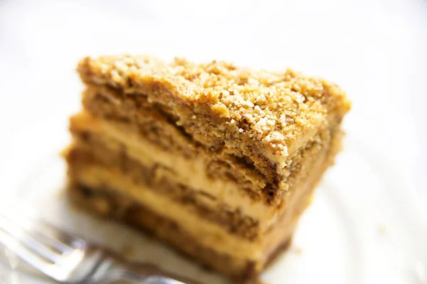 Slice of delicious honey cake on white plate — Stock Photo, Image