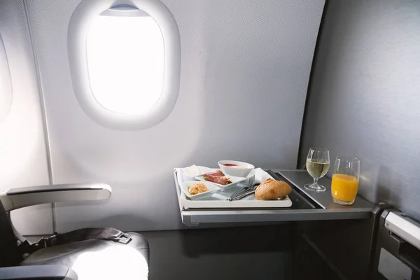 Comida servida a bordo de un avión de clase ejecutiva sobre la mesa — Foto de Stock