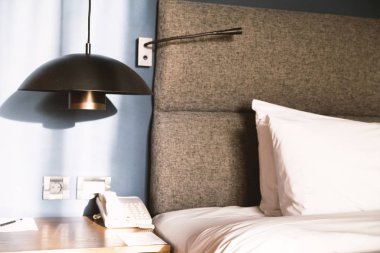 bir yastık, tablo, lamba ve telefon ile yatak