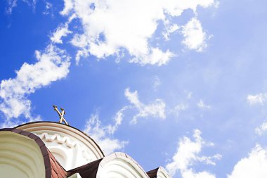 Mavi gökyüzüne karşı bir kilise kubbe üzerinde çapraz