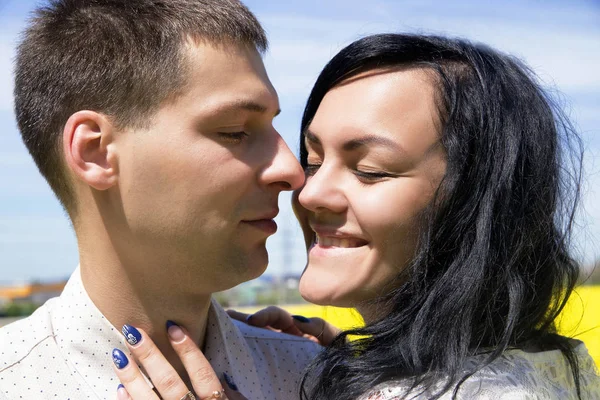 Porträtt av unga glada vackra par på blå himmel — Stockfoto